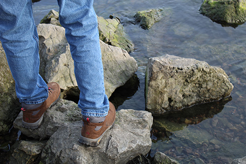 Man standing on rocks in a river.